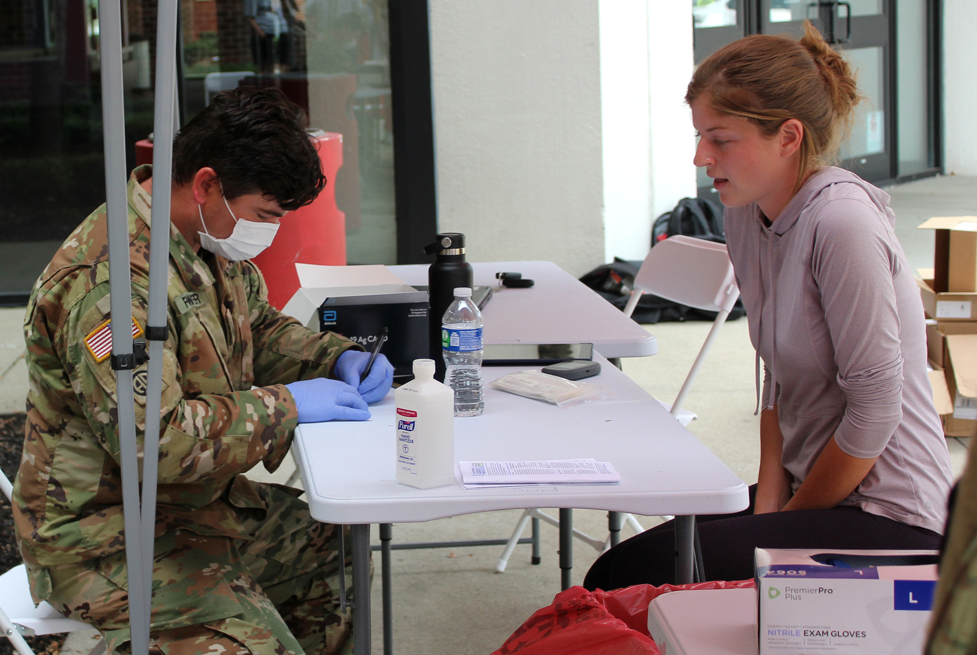 Ohio National Guard Medic Troy Fowler (left) administers a COVID-19 test
