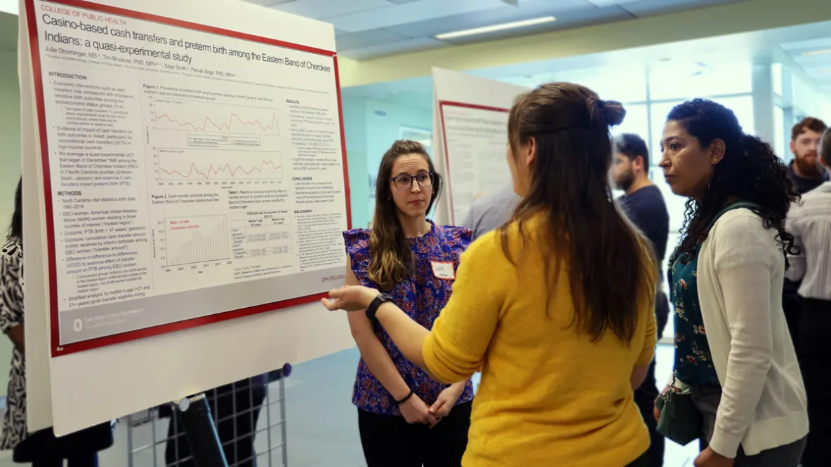 Student presenting research to public health faculty
