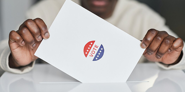 man holding paper with "Vote" icon