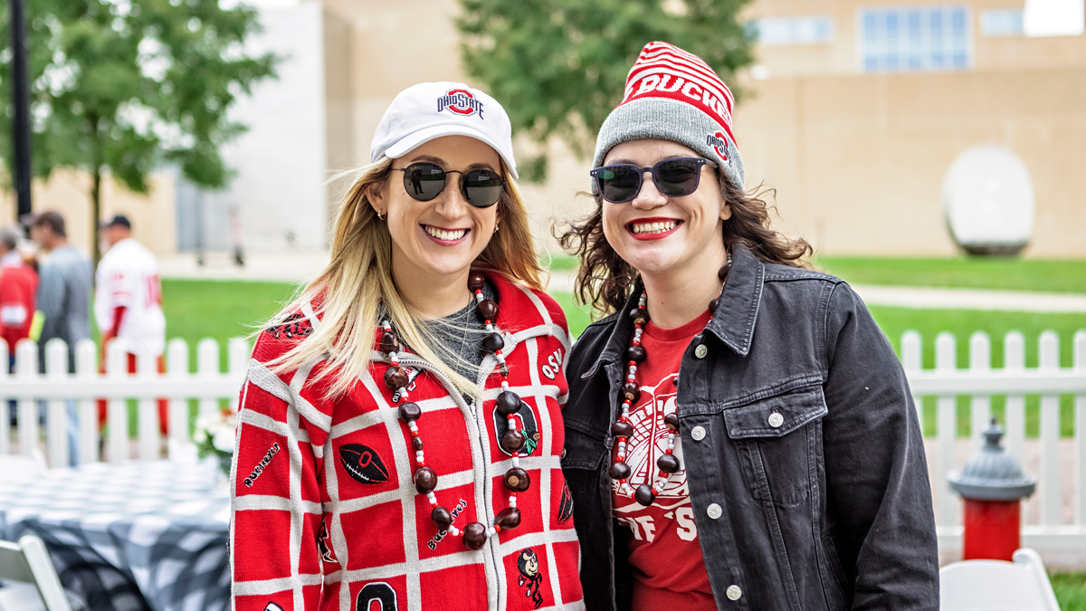 Two women in Ohio State spirit wear at the college's homecoming tailgate