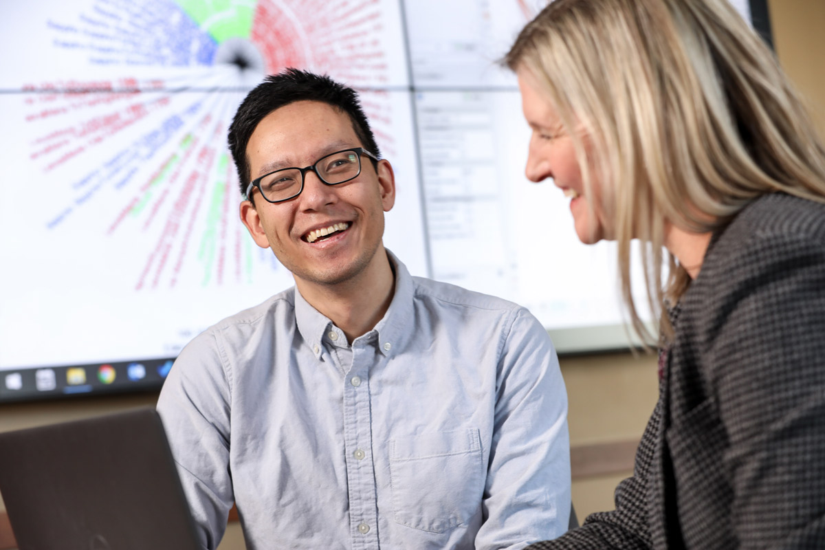 two people laughing with graphs projected in background