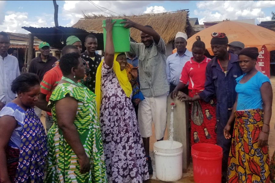 large group of women getting water in containers