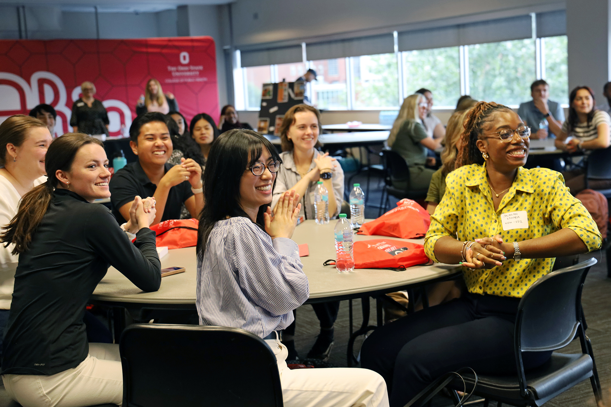 Smiling students sit at a table.