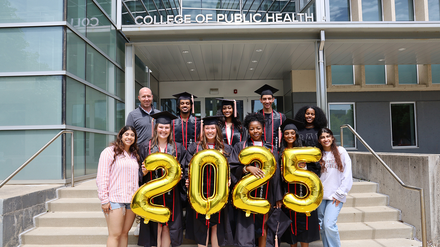 students pose on the steps of Cunz Hall with balloons that spell 2025