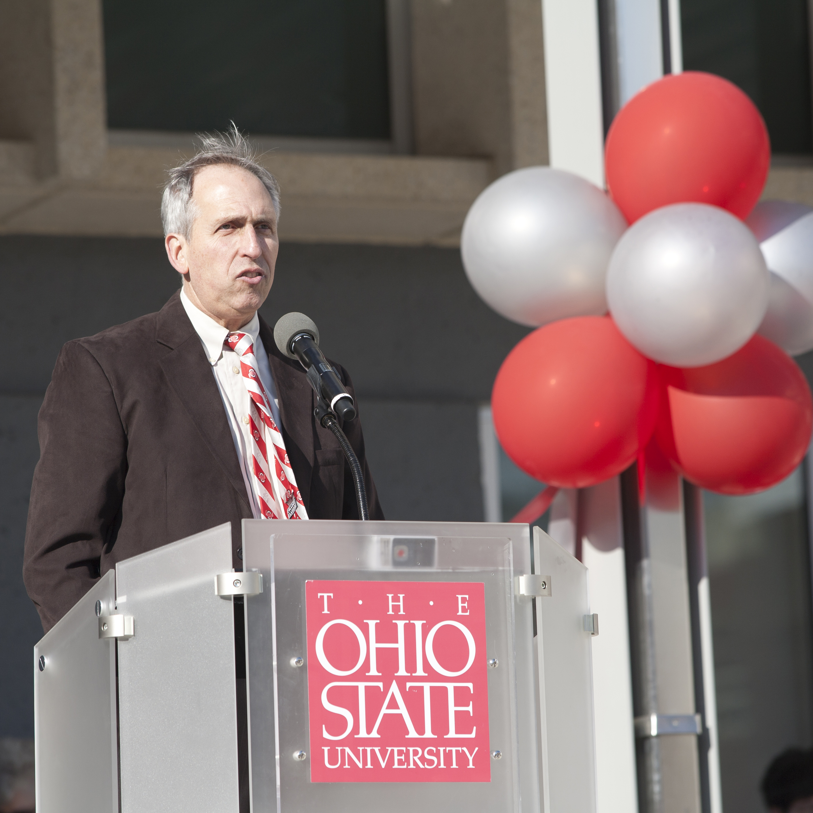 Stan Lemeshow stands at a lectern in front of Cunz Hall.