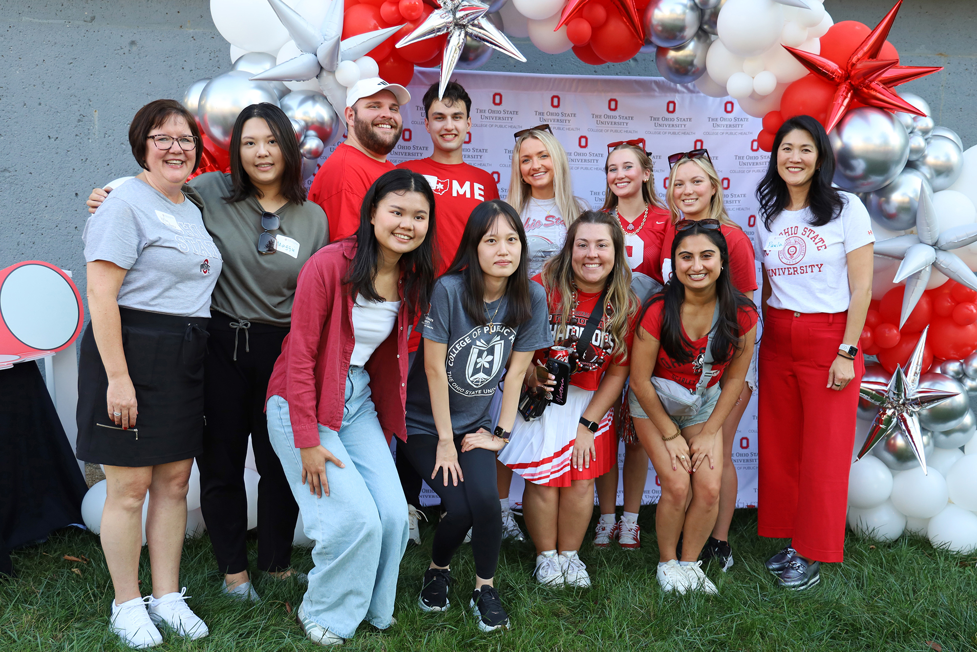 A group of people dressed in Buckeye attire smile.