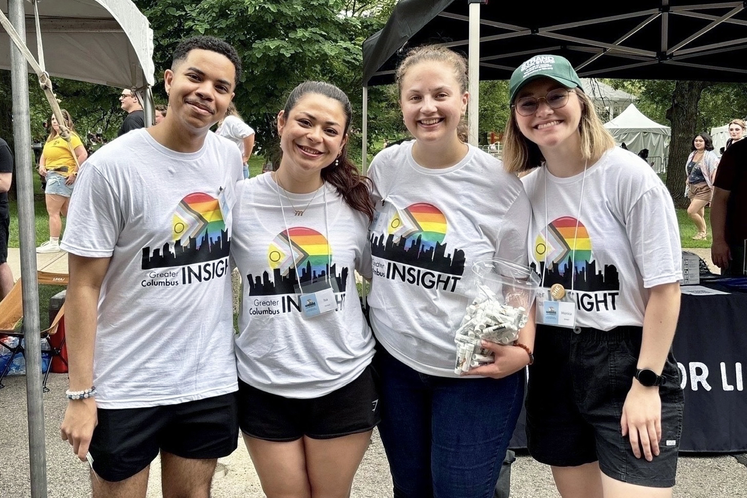 Four people in white shirts pose for a photo