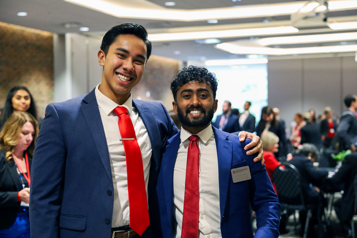 Two Master of Health Administration students in blue suits and red ties