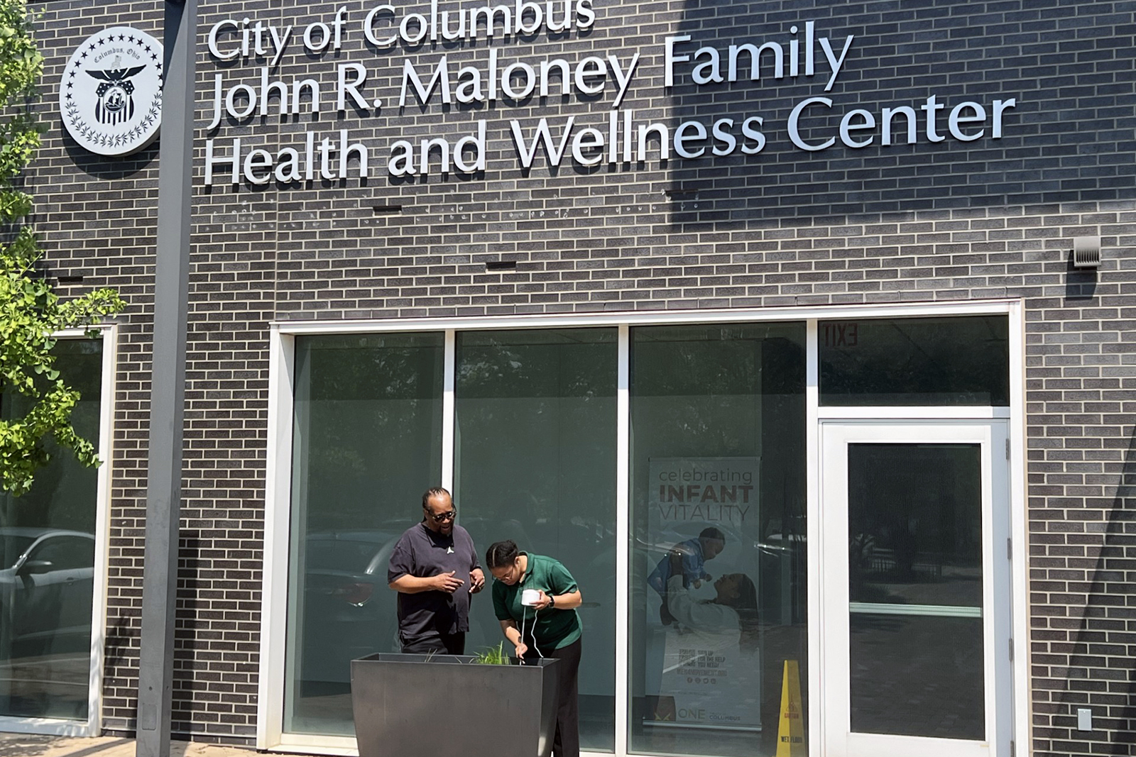 Opal Moore and Darryl B. Hood in front of the John R. Maloney Family Health and Wellness Center