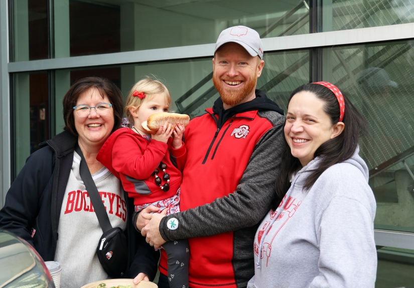 Four people pose for a photo at the CPH Homecoming tailgate