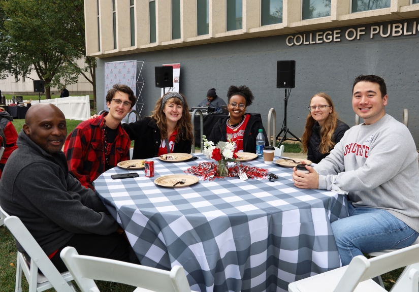 A table of students pose for a photo with James Odei