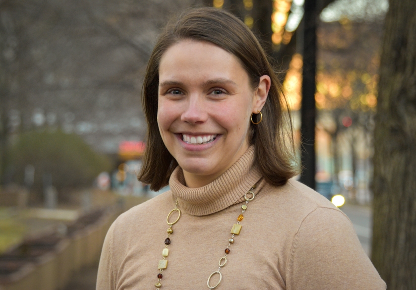 Angie Byrne smiling wearing a brown turtleneck sweater.