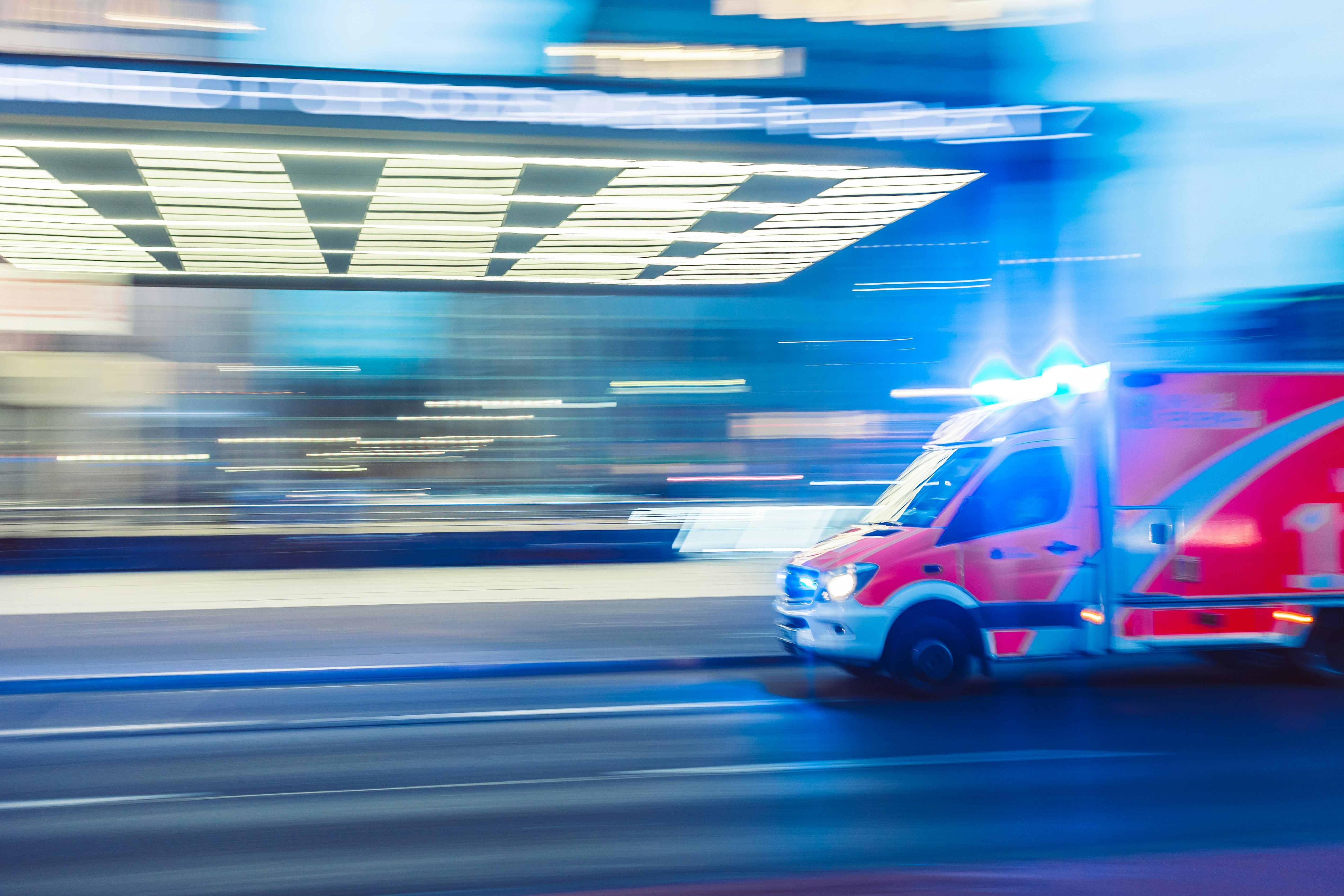 A red ambulance racing down the road