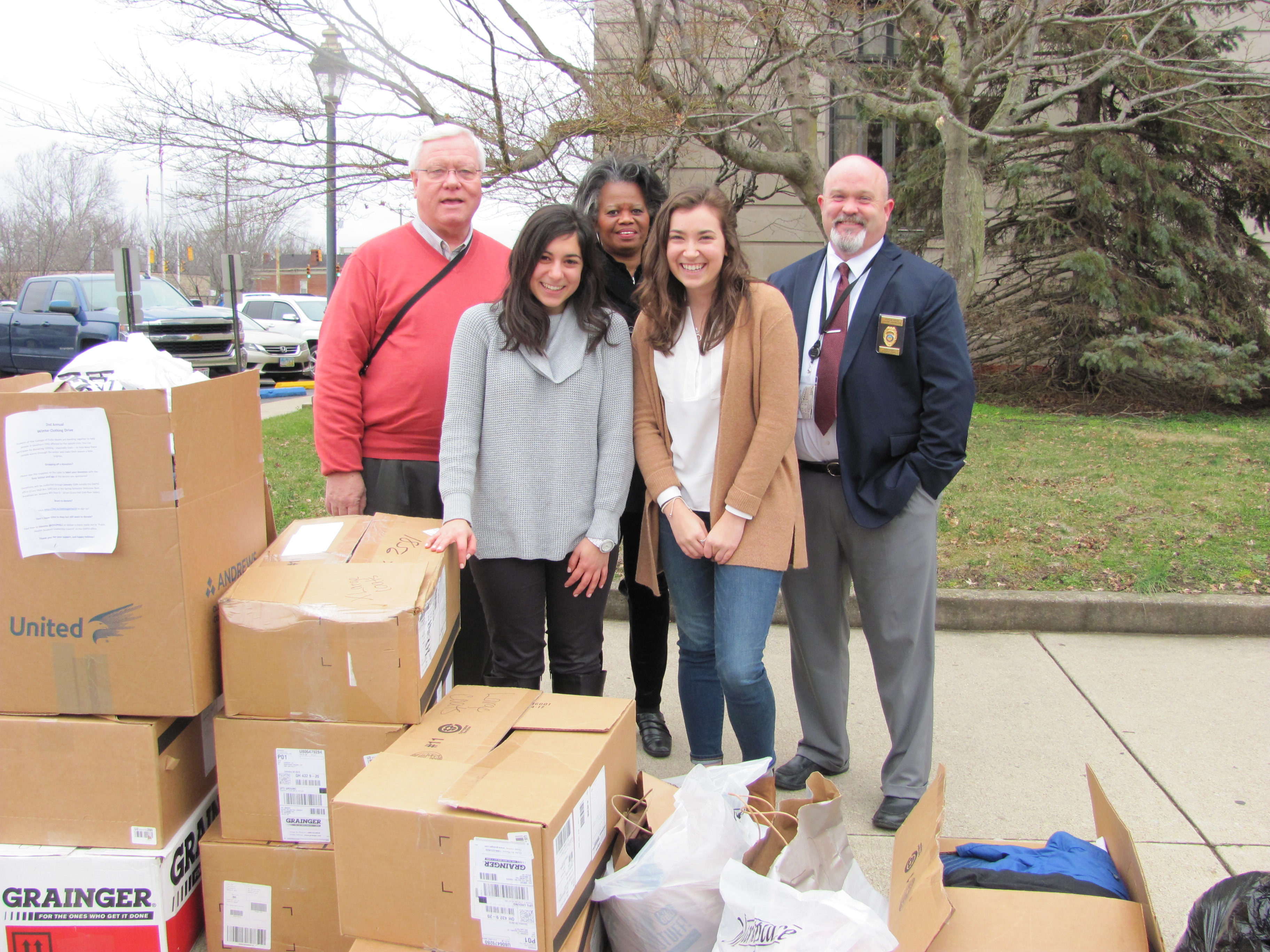 Students Hannah Piscalko (front left) and Elli Schwartz (front right), with epidemiology research associate Deborah Jones (back center), delivering winter clothing to officials in Scioto County.