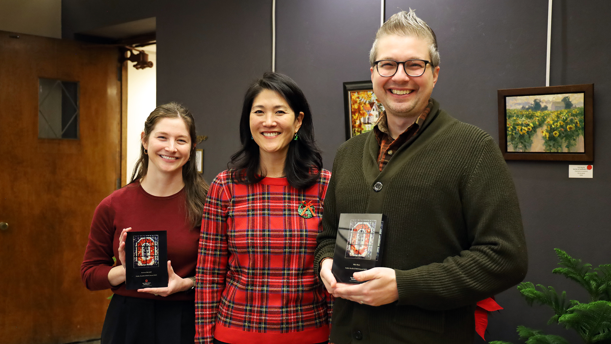Kristen Mitchell and Mike Mara hold awards next to Dean Paula Song