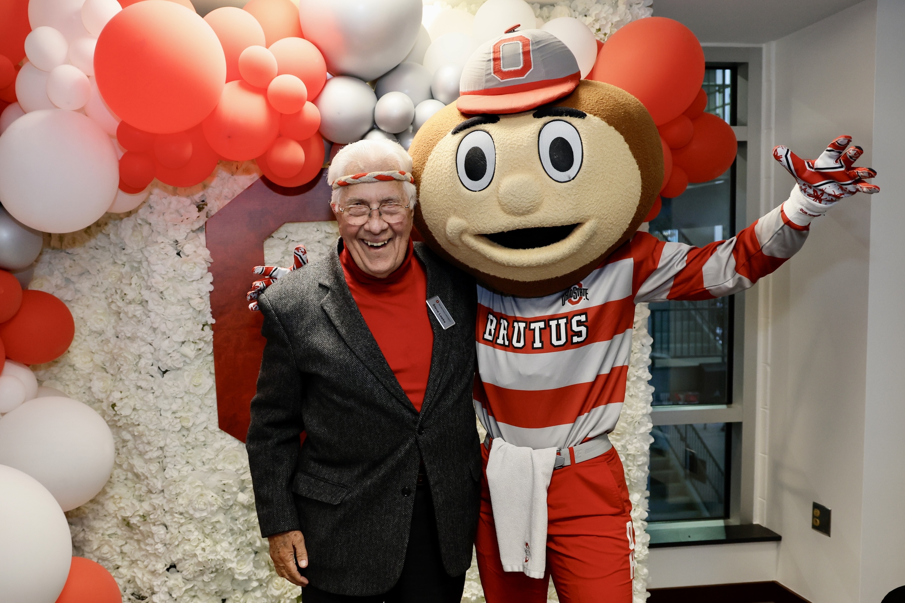 Steve Loebs with Brutus Buckeye surrounded by red and white balloons
