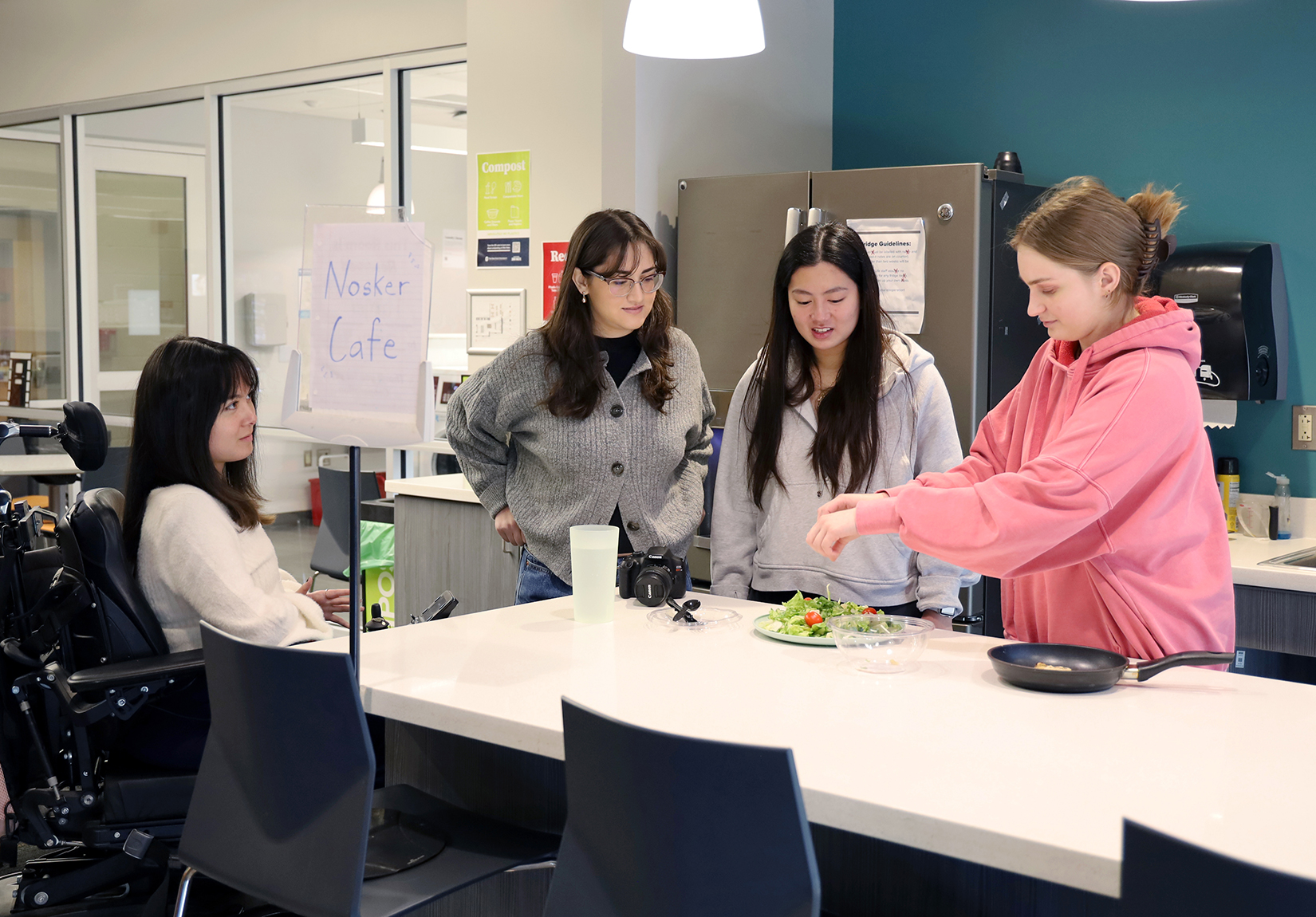 students prepare a salad in the Nosker House kitchen.