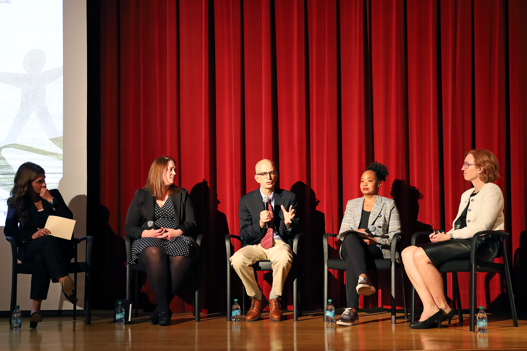 five panelists sit on a stage.