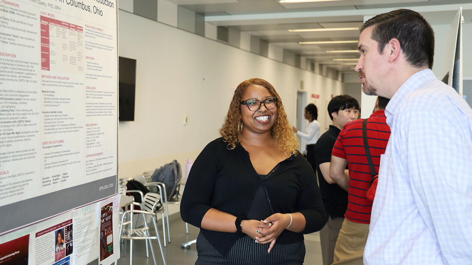 Micah Morris speaks to Dr. Jeffrey Wing next to her research poster.