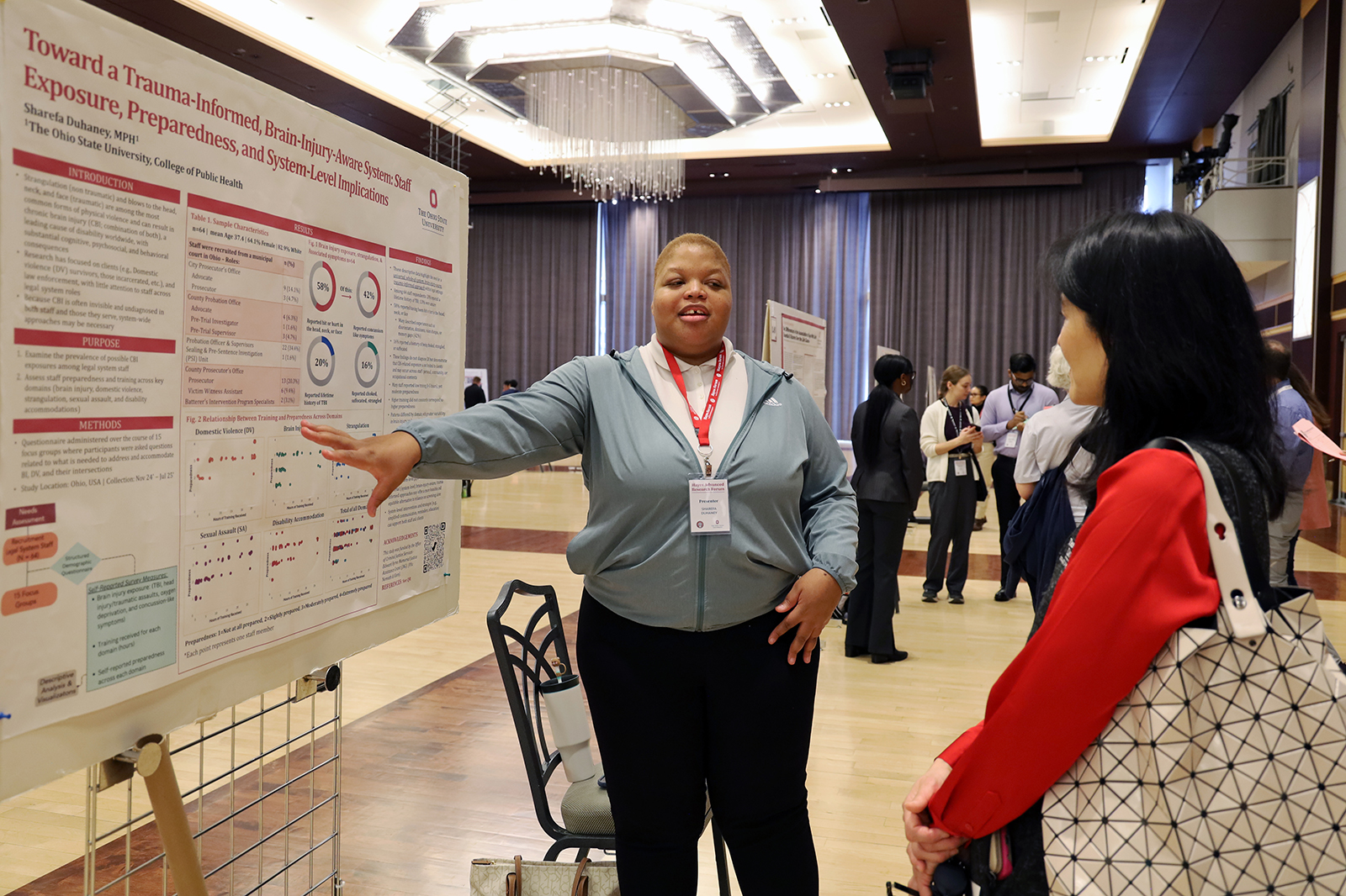 Sharefa Duhaney points at her research poster while Dean Paula Song listens