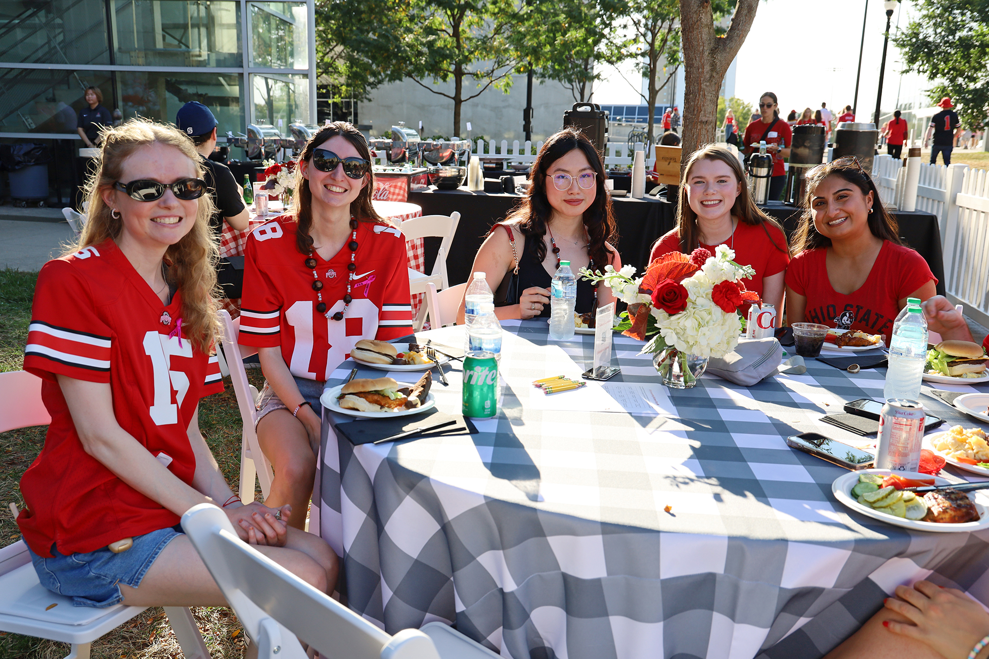 A group of people sit around a table outside. 