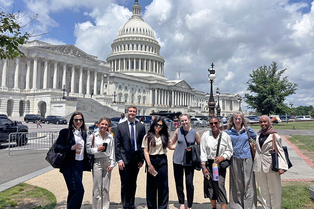 Students and Amy Ferketich pose for a photo in front of the U.S. Capitol.