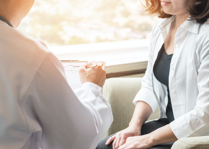 woman speaking with medical staff