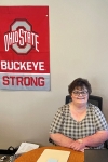 Cathy Neal in her office with Ohio State poster in background