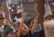 dissertation masters vs phd Woman in crowd holding "my body my choice" sign