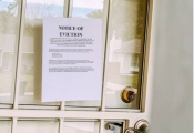 A door with an eviction notice taped to it.