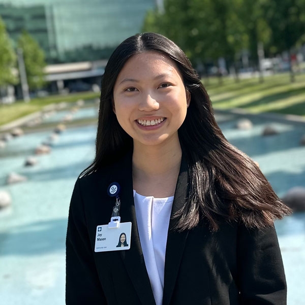 young woman smiling while standing in front of a pool of water at a health care site