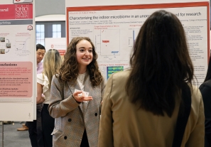 Olivia Farinas speaks to a Denman Undergraduate Research Forum attendee on March 5, 2024. 