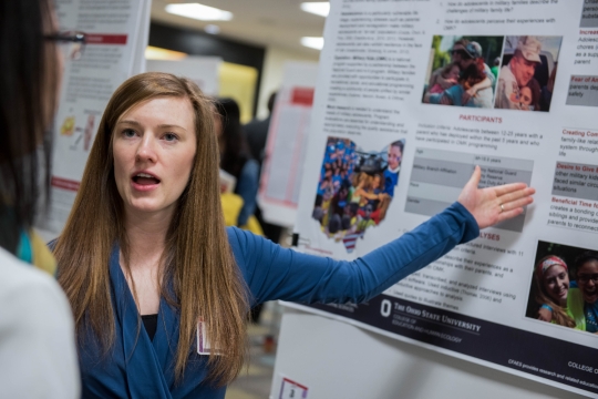 student explaining research poster