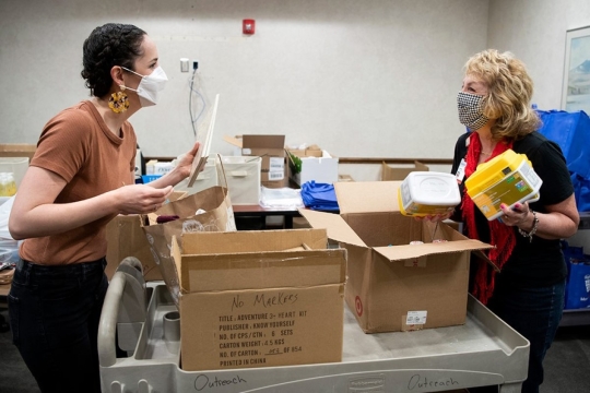 two people preparing outreach packages