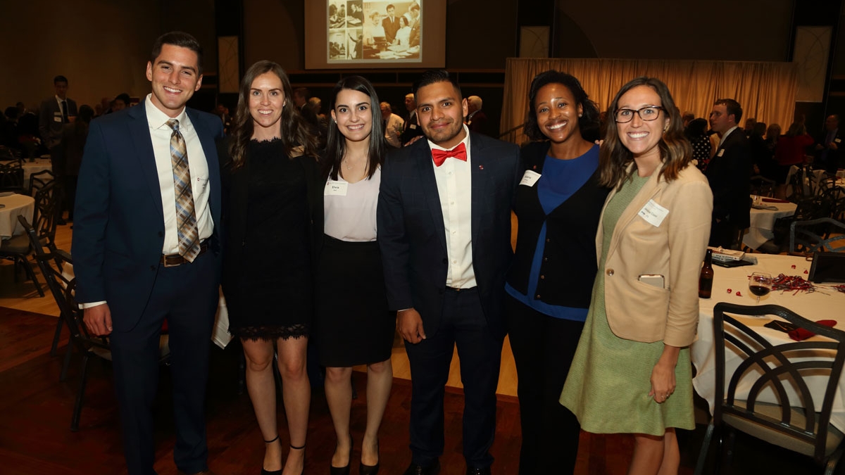 Group of six alumni at an event