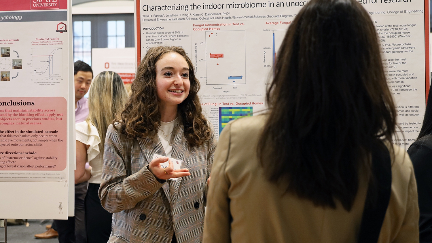 Olivia Farinas speaks to a Denman Undergraduate Research Forum attendee on March 5, 2024.