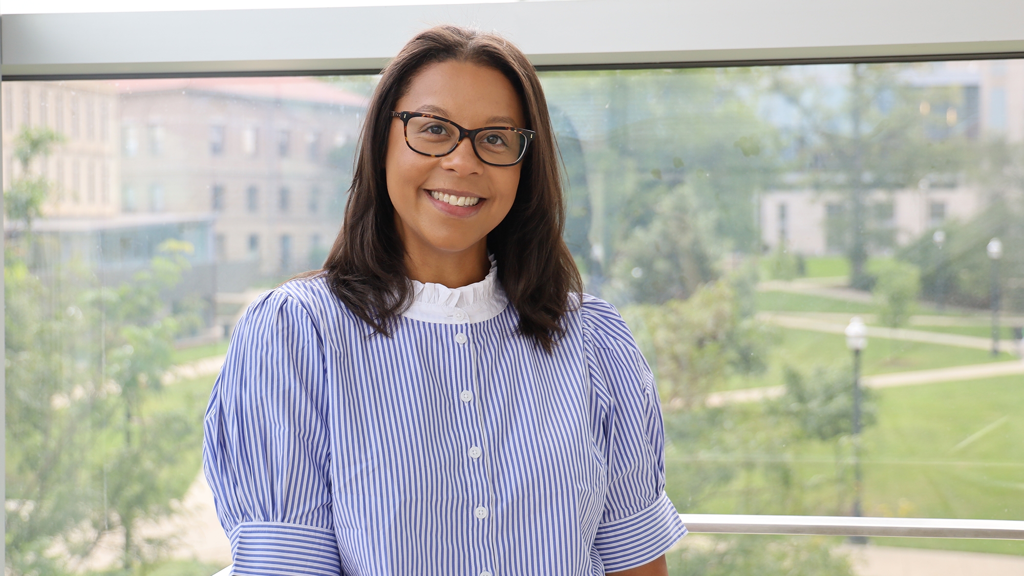 Photos of Ashley Felix smiling with Thompson Library int he background.