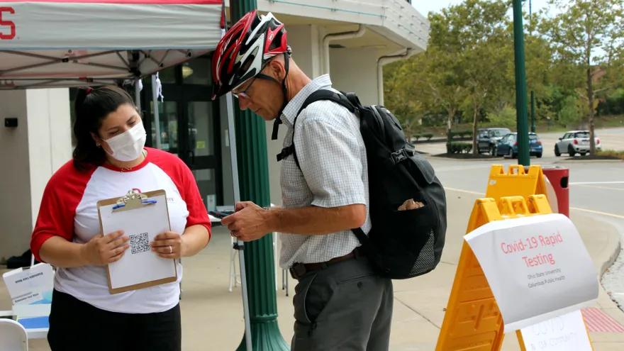 A public health student interacts with a resident at a pop-up health education event