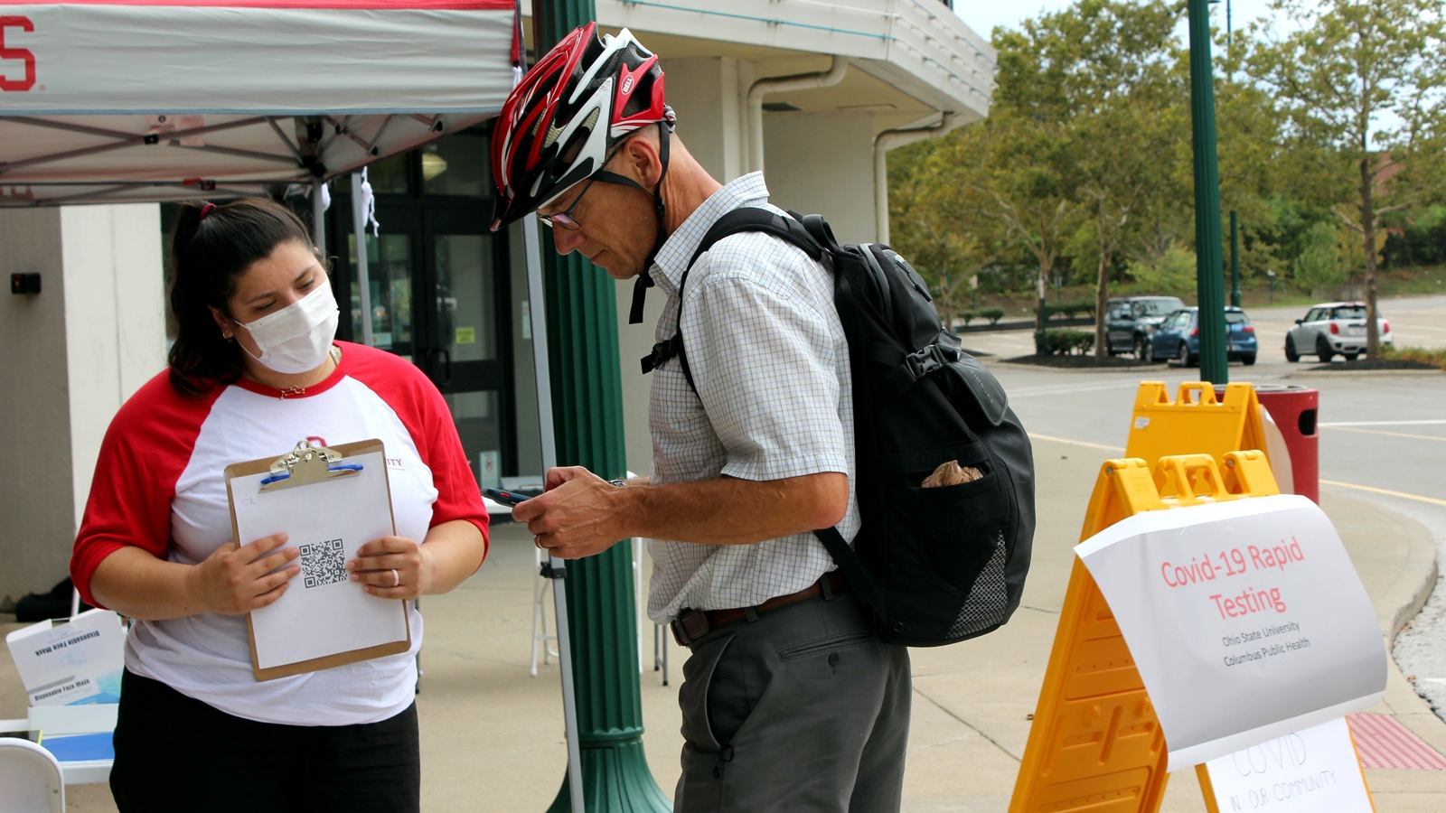 A public health student interacts with a resident at a pop-up health education event