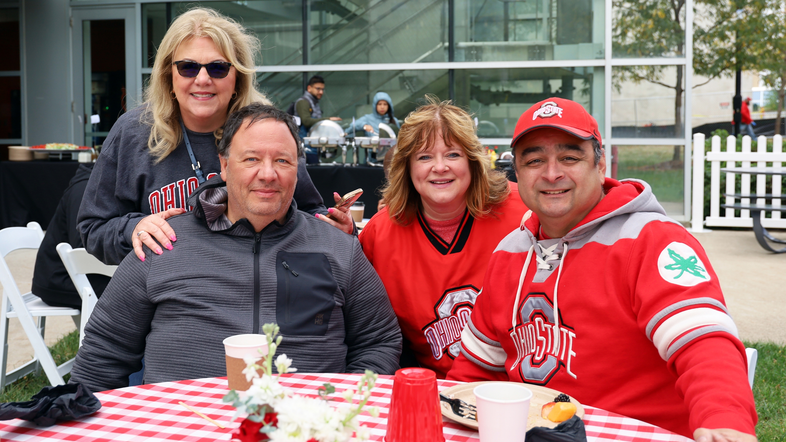 Four people pose for a photo at the CPH Homecoming tailgate