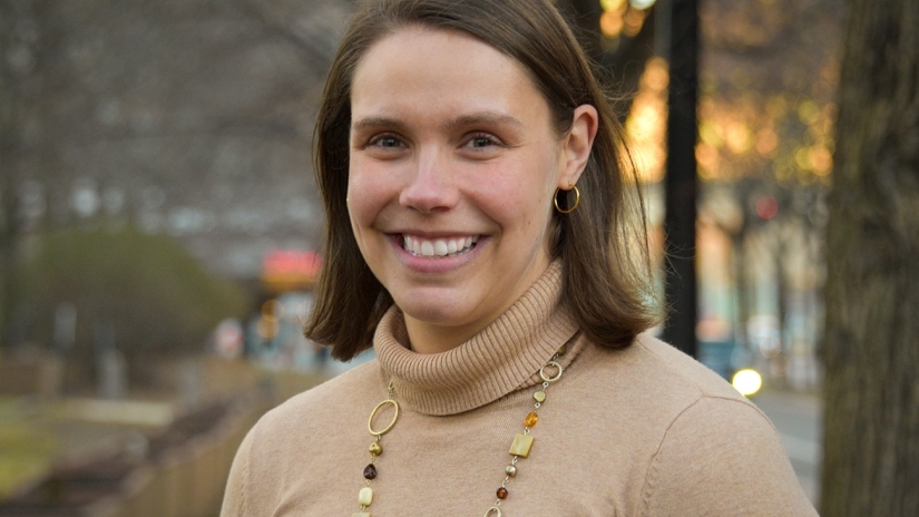 Angie Byrne smiling wearing a brown turtleneck sweater.