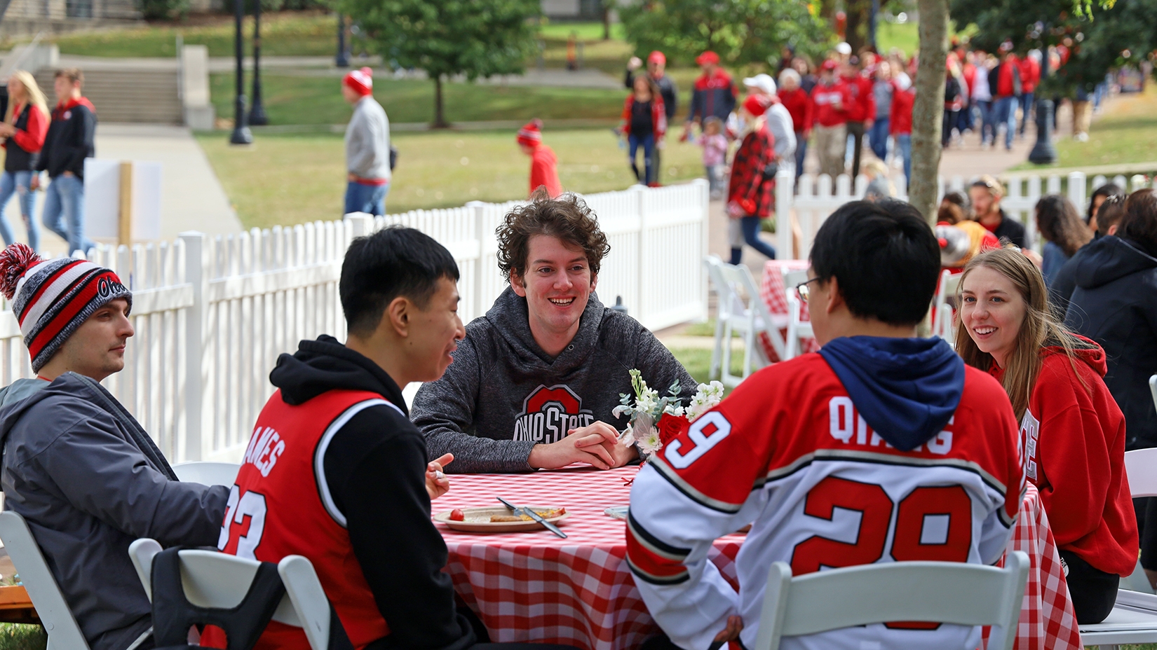 Students interact around a table at the CPH Homecoming tailgate