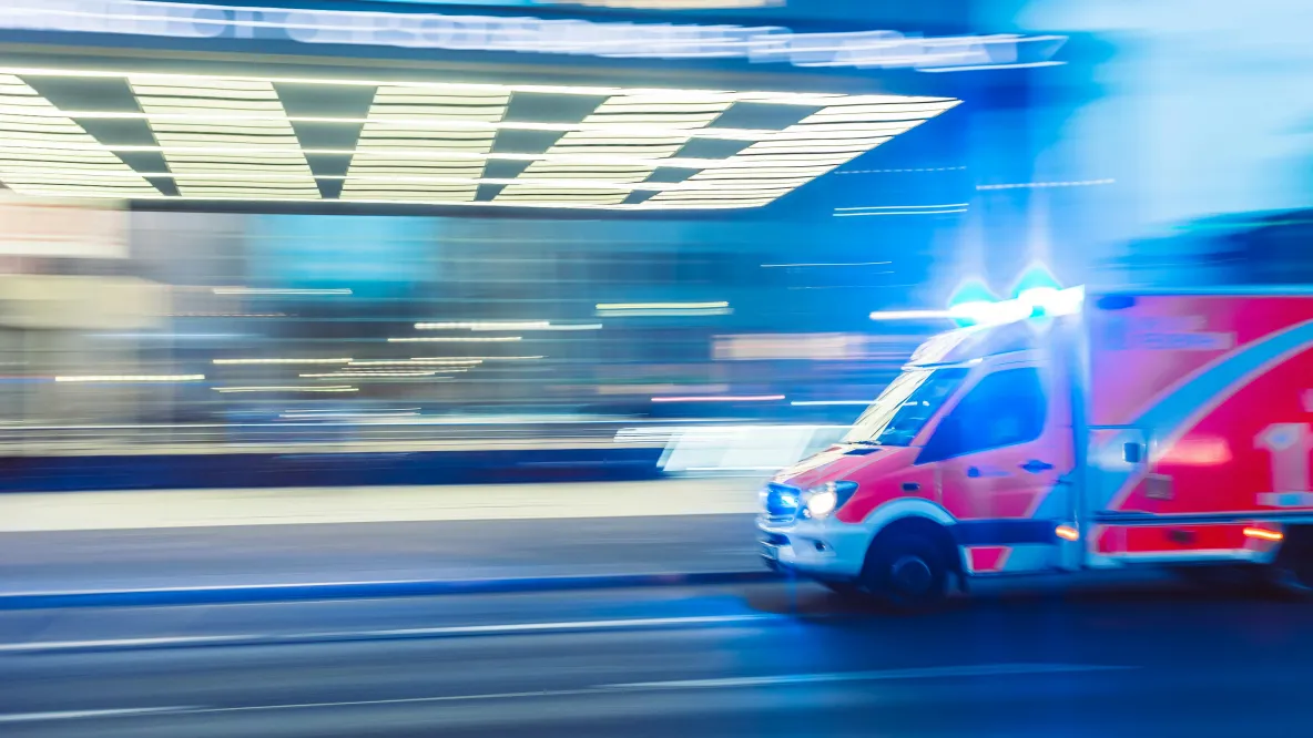 A red ambulance racing down the road