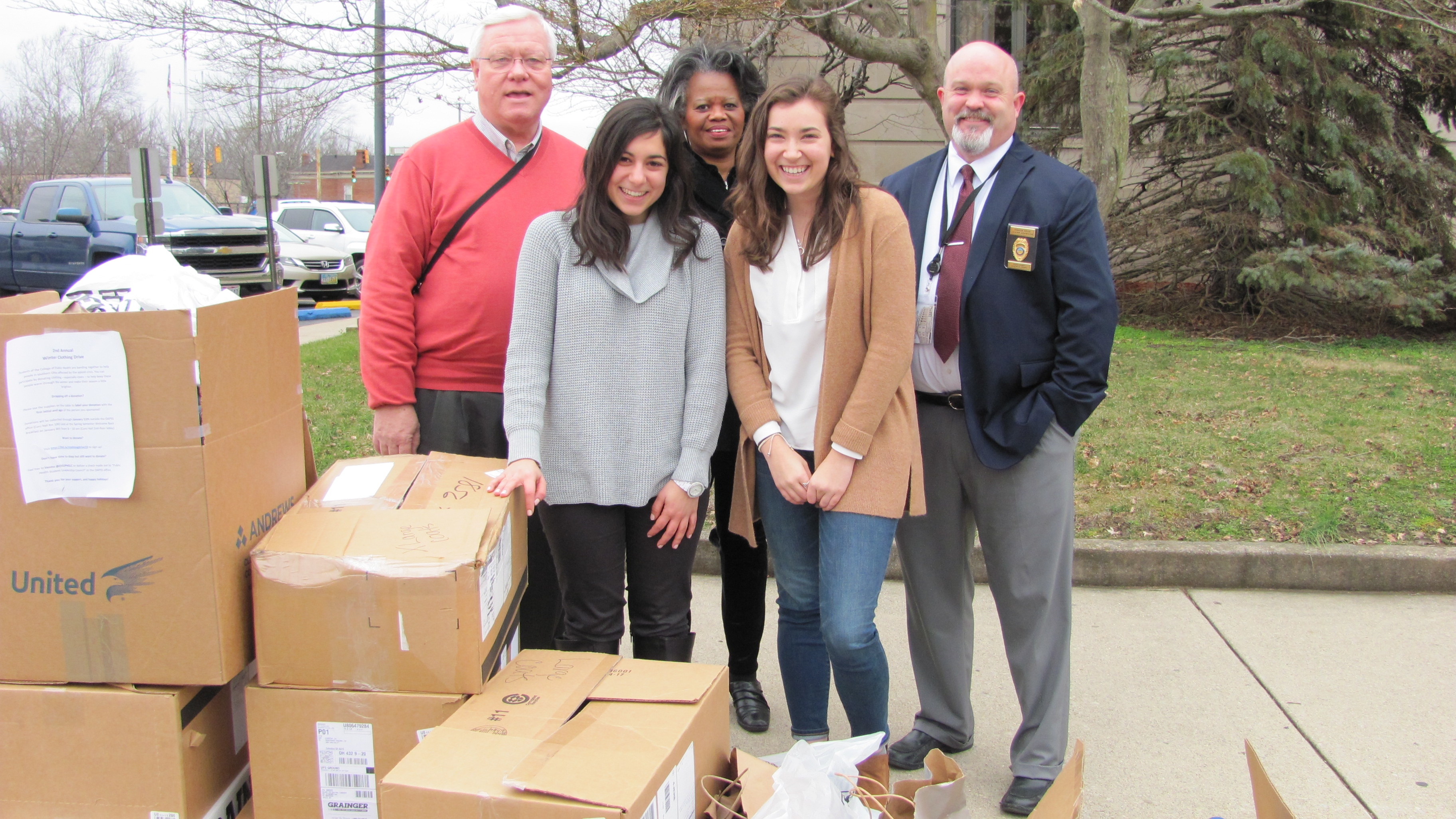 Students Hannah Piscalko (front left) and Elli Schwartz (front right), with epidemiology research associate Deborah Jones (back center), delivering winter clothing to officials in Scioto County.