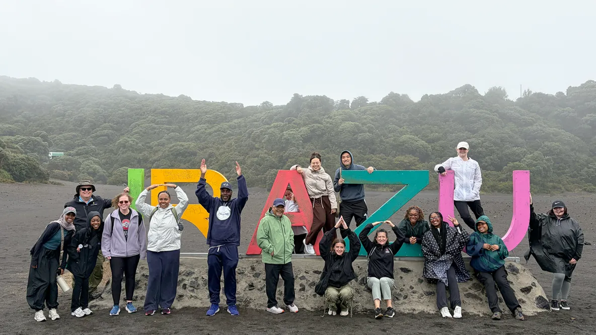 College of Public Health students stand around large colorful letters in Costa Rica. 