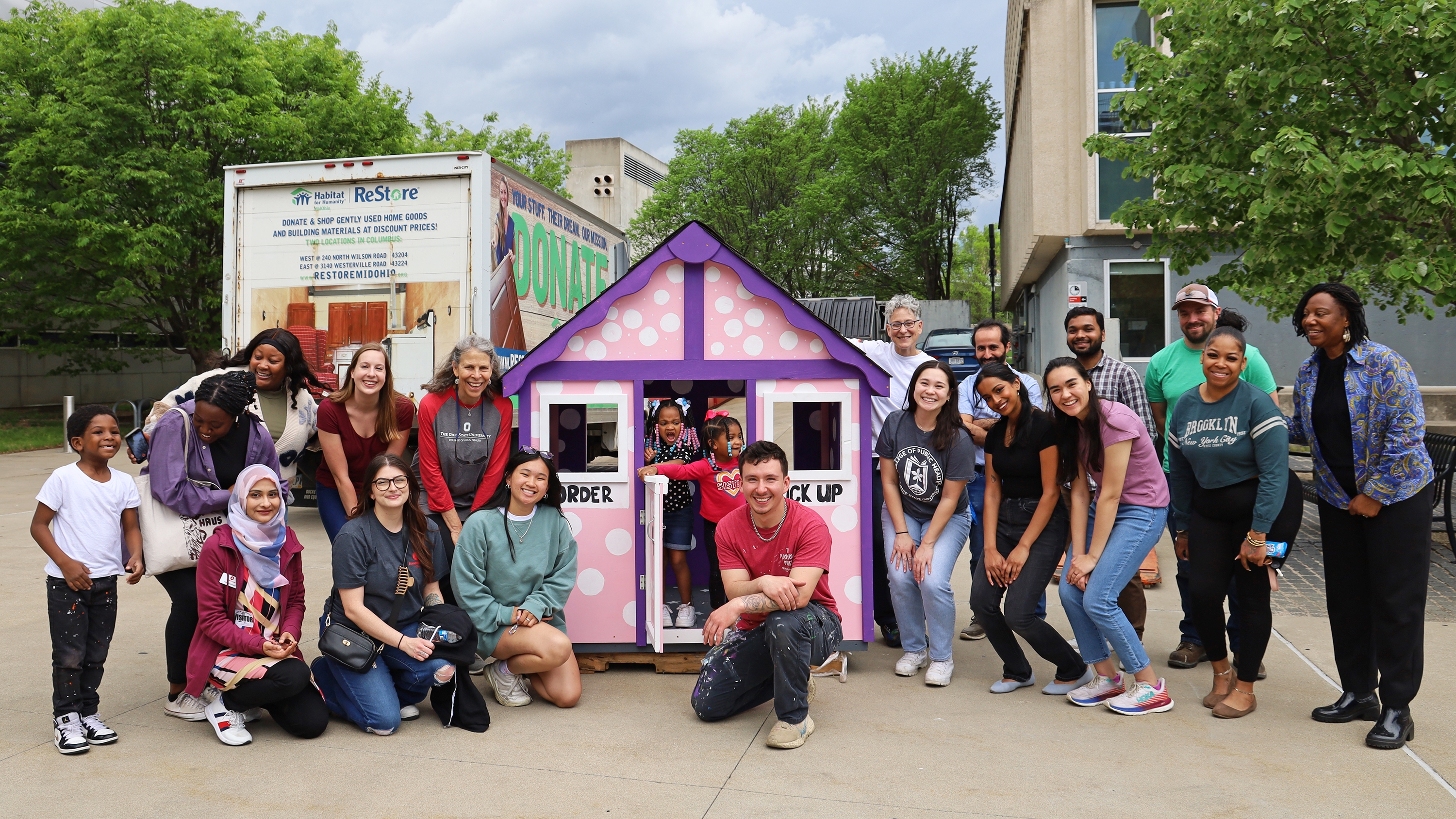 Members of the CPH community pose with a playhouse they built on April 17, 2024.