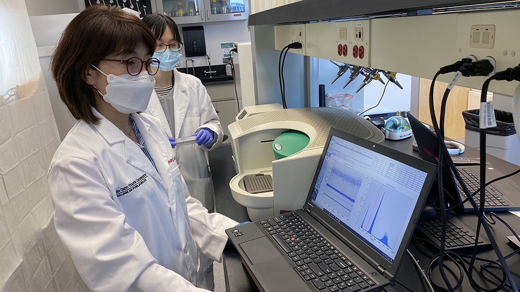 Jiyoung Lee, left, and PhD student Yuehan Ai check SARS-CoV-2 genetic copy data using droplet digital PCR.