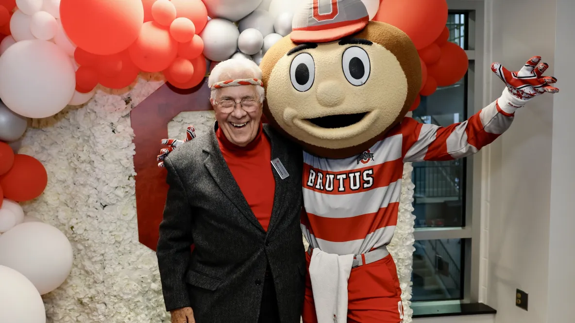 Steve Loebs with Brutus Buckeye surrounded by red and white balloons