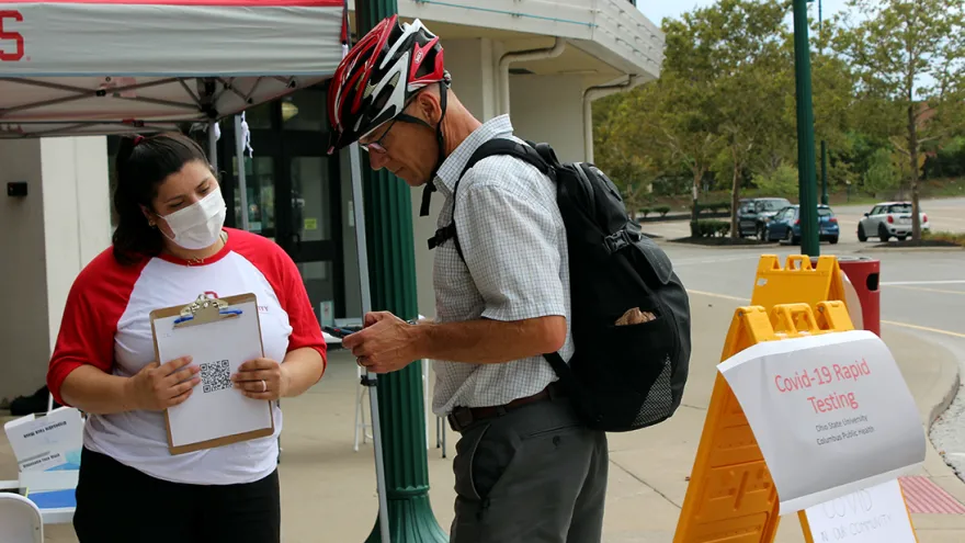 Fourth-year public health student Lauren Putz helps check in a community member for a COVID-19 test