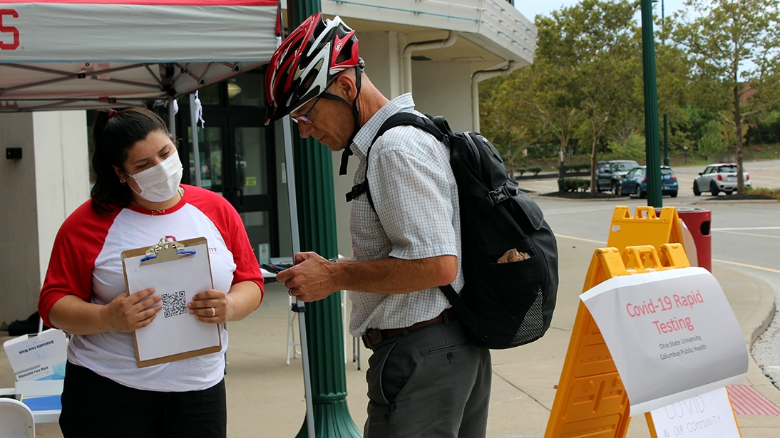 Fourth-year public health student Lauren Putz helps check in a community member for a COVID-19 test